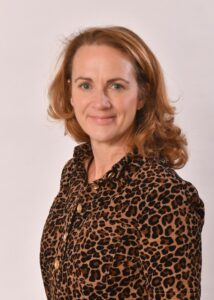 head & shoulders of a woman in a leopard skin shirt