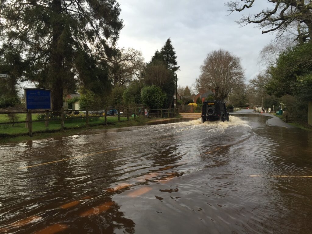 a landrover driving through flooded water