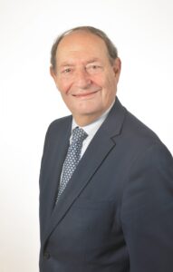 head & shoulders of a man in a blue jacket, shirt and tie