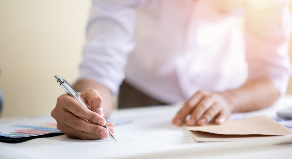 person writing on a paper document
