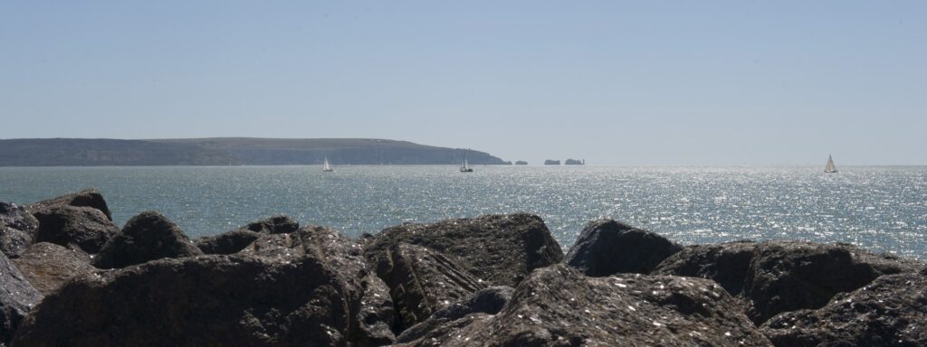 Sunlight on the ocean, with rocks in the foreground