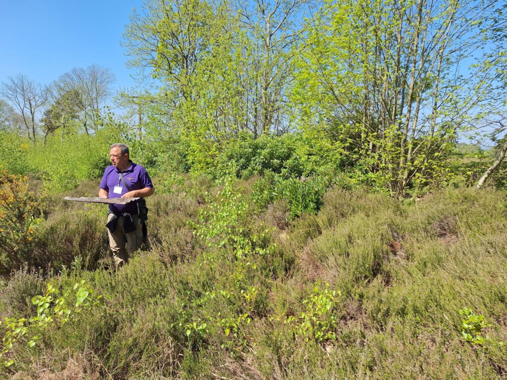 a man doing a survey in an overgrown area of countryside
