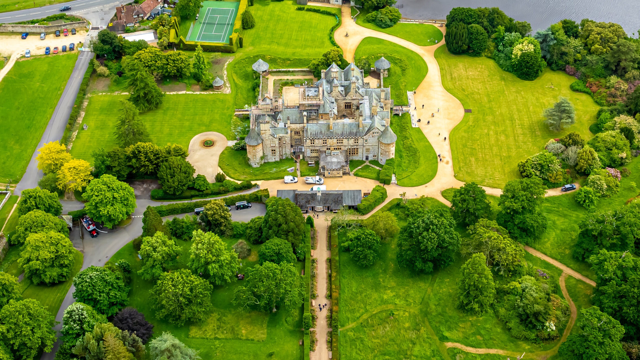 Aerial view of a large stately home surrounded by lawns and trees