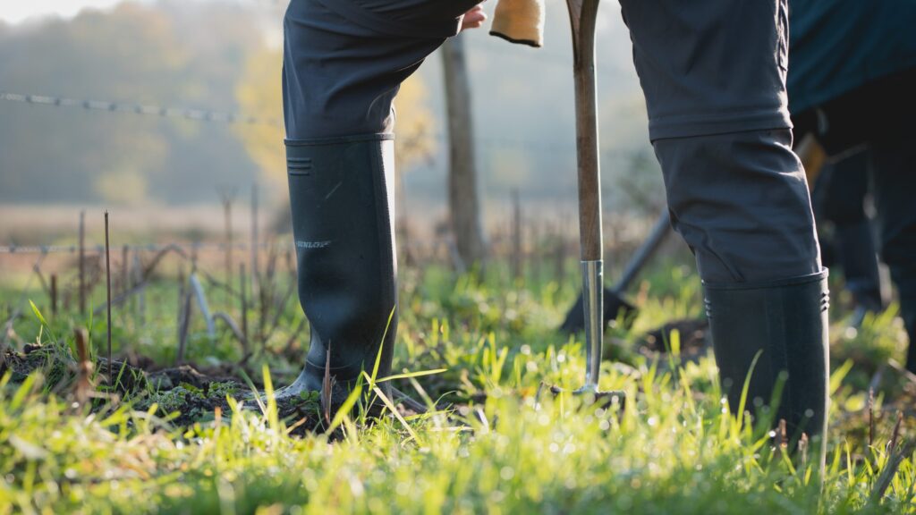 Wellies on grass with a person digging