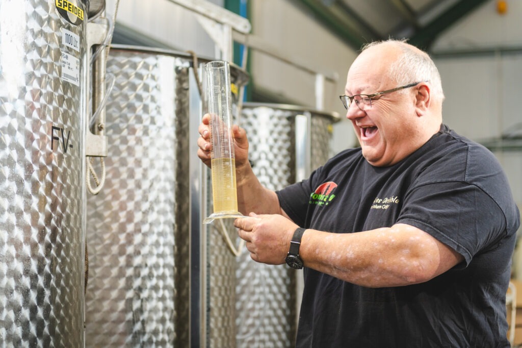 Man in a brewery pouring cider