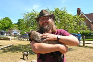 CET staff member Kristian Markusen holding a lamb and smiling