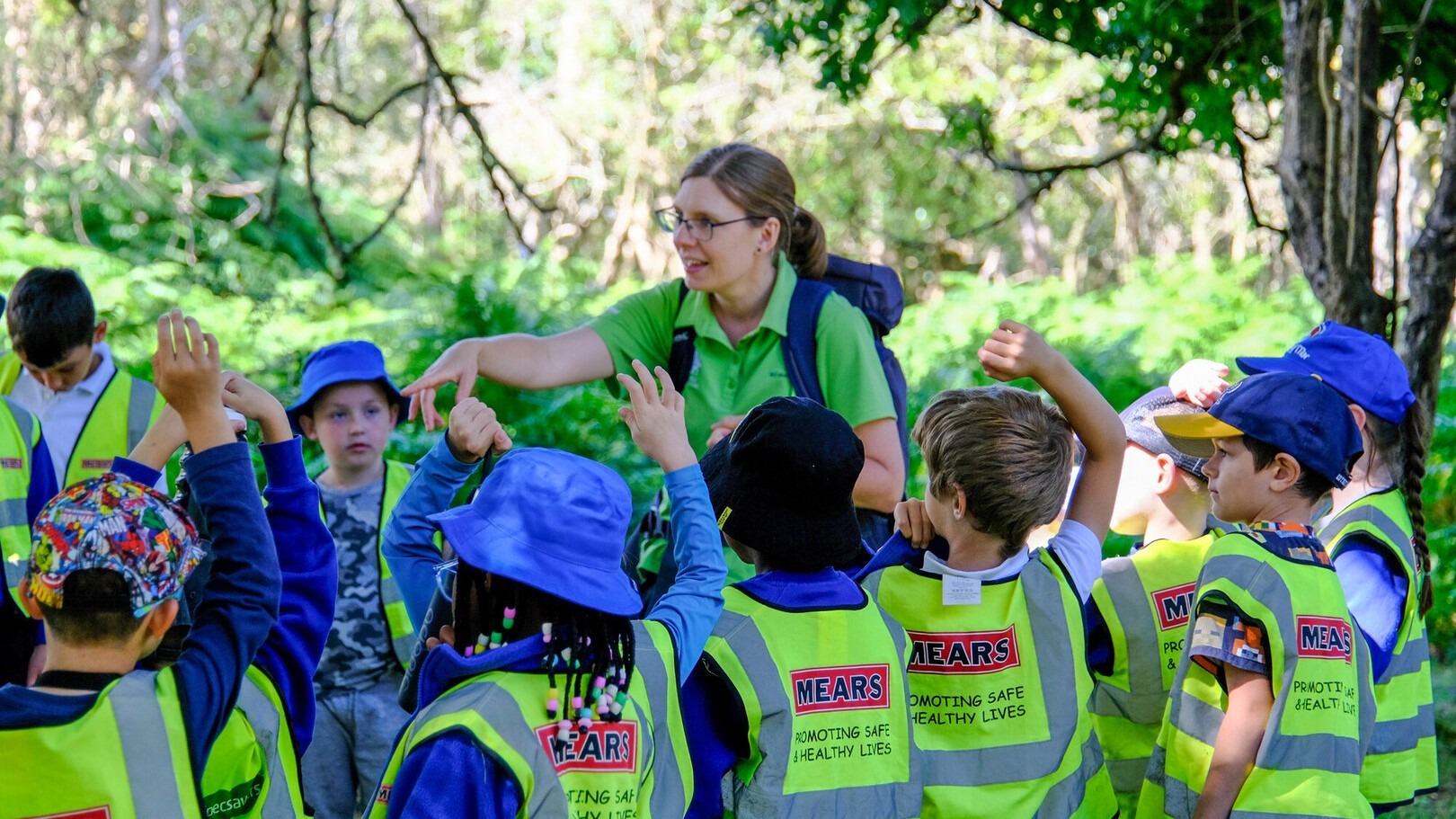 a teacher talking to a group of children outdoors