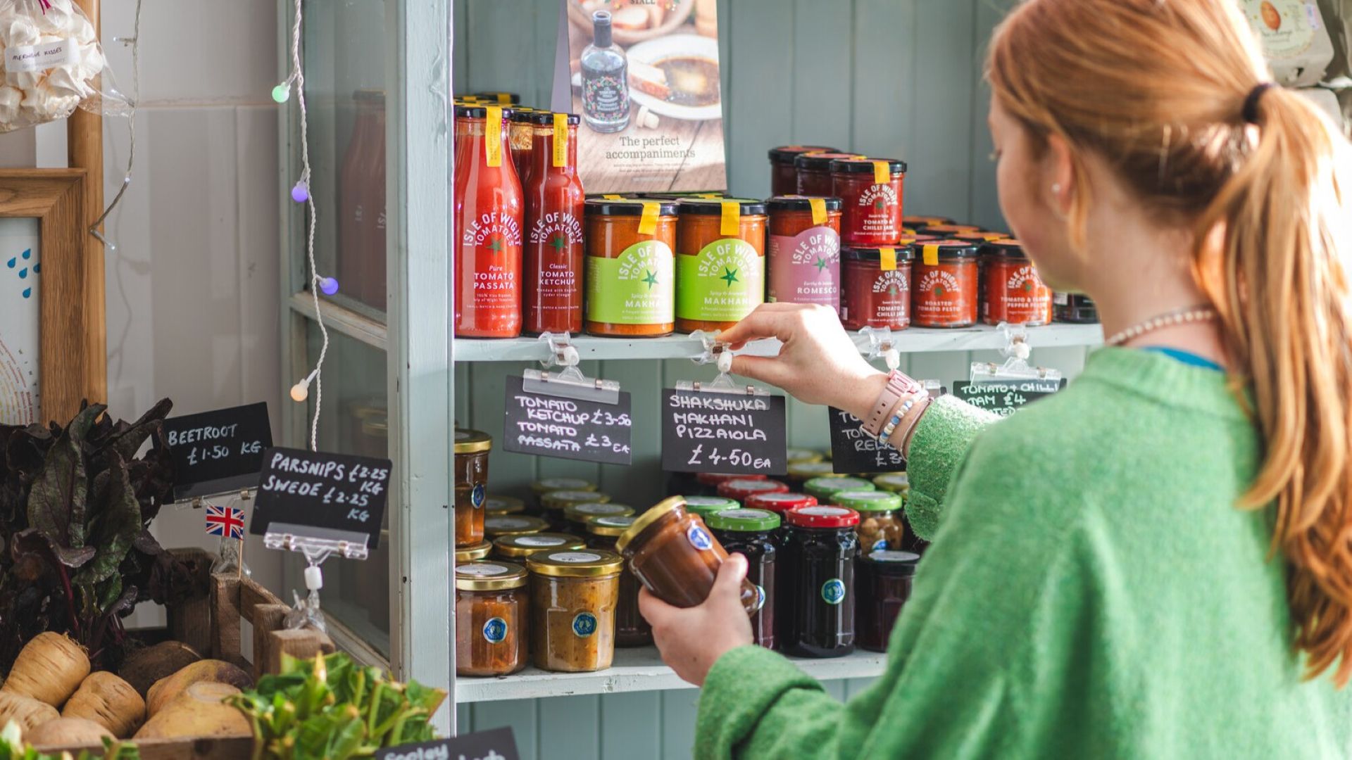 a person picking jam jars from a shop shelf