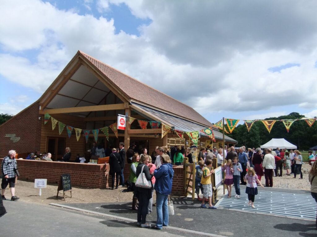 a wooden shop building with bunting and people standing around outside