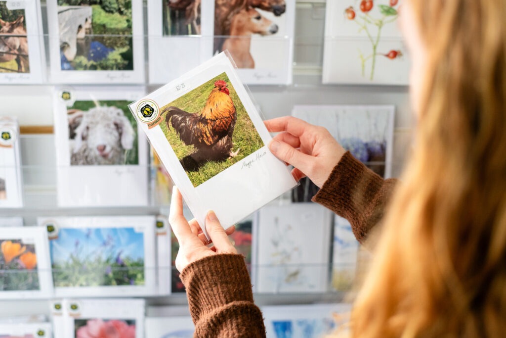a lady looking at a greeting card in a shop