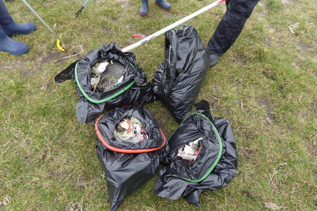Four black bin bags on the floor after a litter pick.
