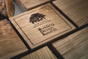 Engraved oak award plaque reading New Forest National Park Building Design Awards, surrounded by wooden blocks