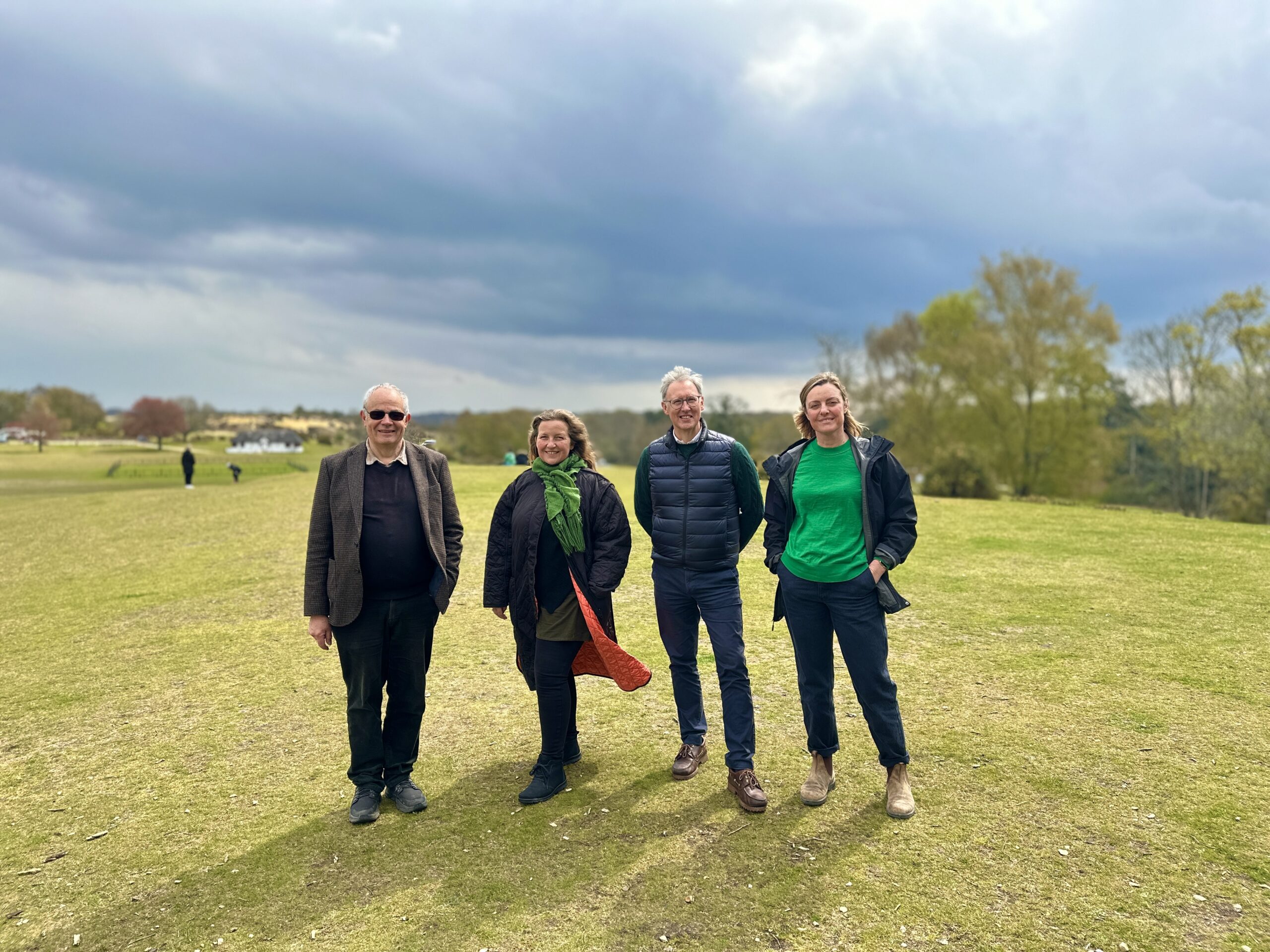 Trevor Beattie, Alison Barnes, Professor Gavin Parker and Vanessa Rowlands standing on grass under dark clouds at Hampshire Hedge launch 2023