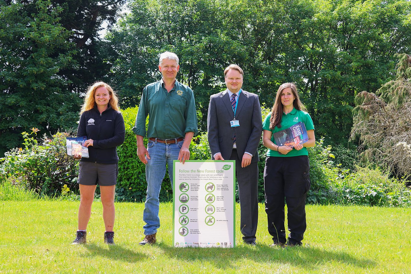 Group of people outside with a sign of the New Forest Code
