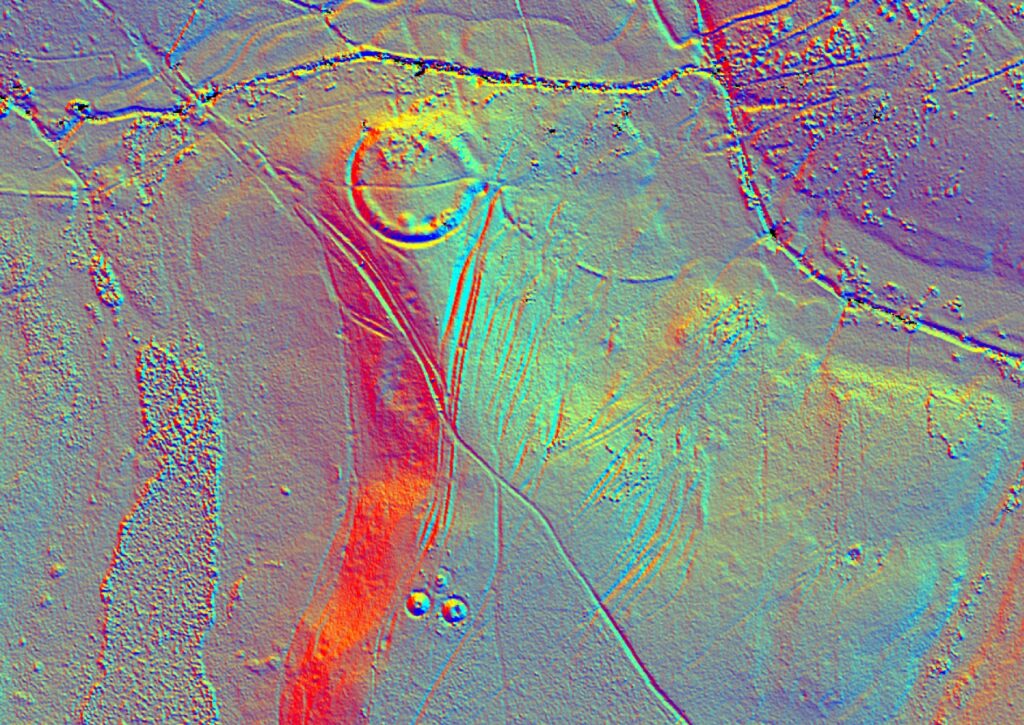 LiDAR terrain map showing circular ramparts of an Iron Age hill fort at Home Farm, with surrounding field boundaries and tracks