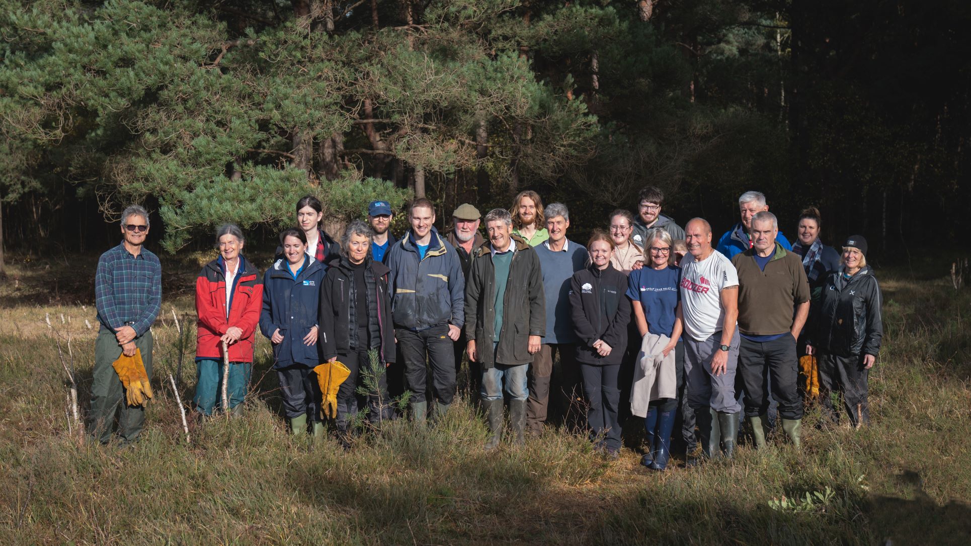 Group of volunteers holding tools in a heathland nature reserve