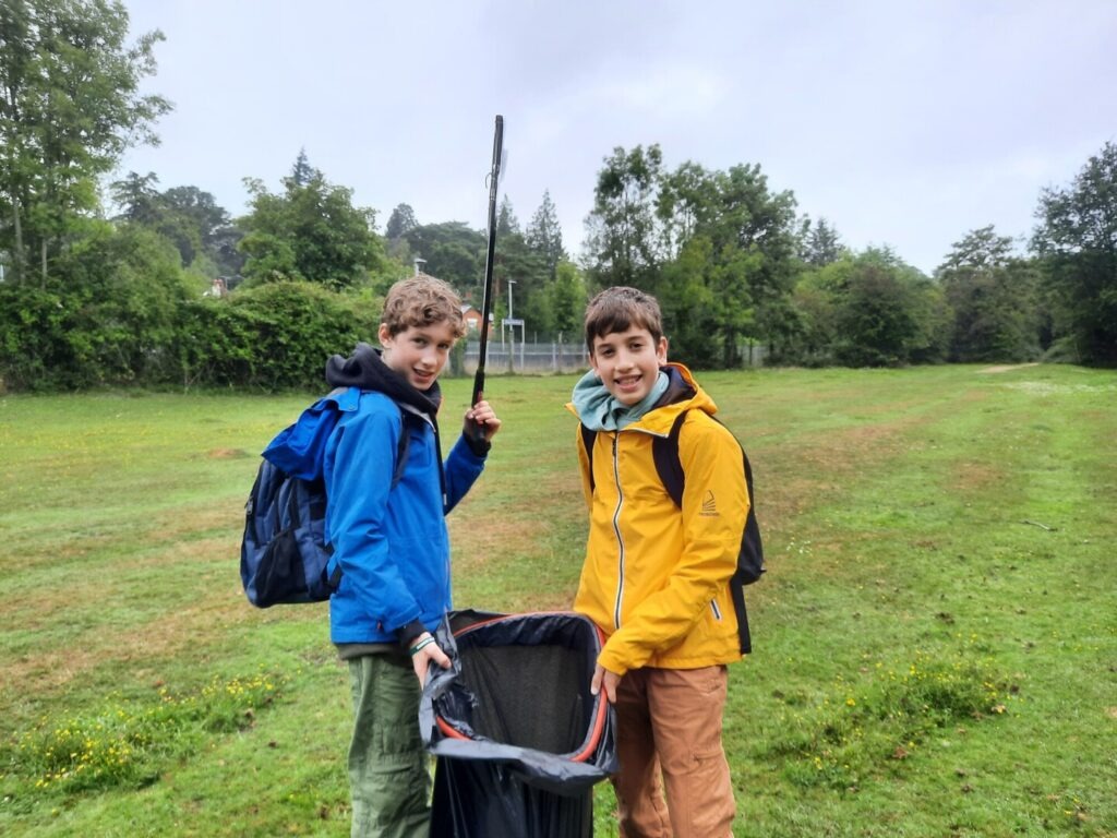 Two teenage boys with a bin bag and litter pickers