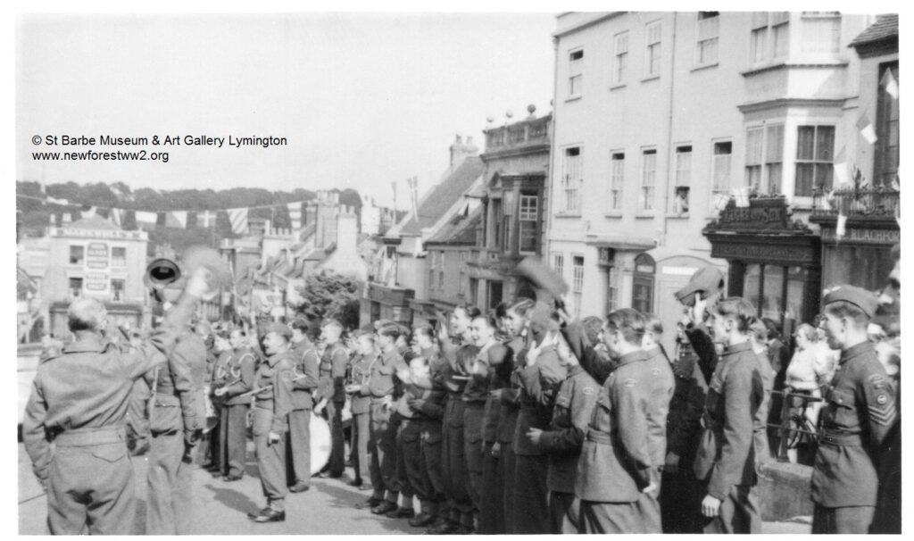 Troops cheering in celebration of VE day on the High Street, Lymington. 1945.