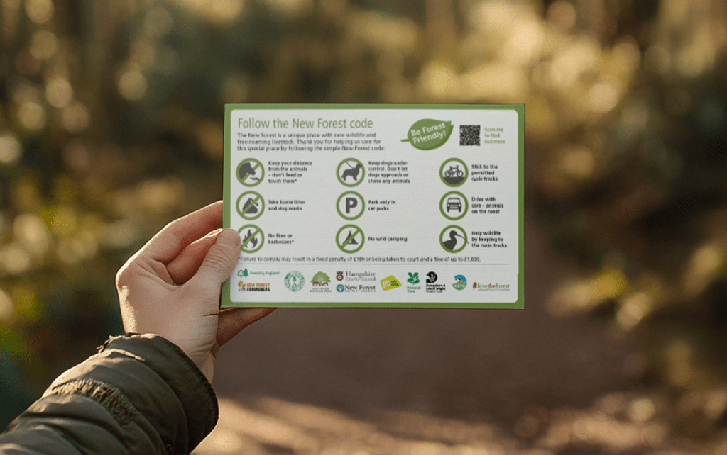 A person's hand hold out the New Forest code.